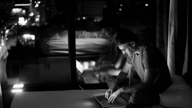 man working on laptop at night from home